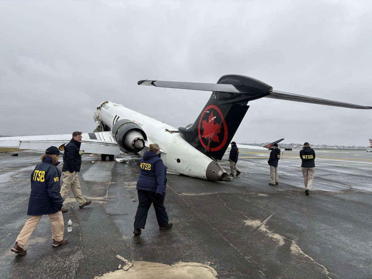 NTSB investigators examining the wreckage of Air Canada Express Flight 8646 on the runway at LaGuardia Airport